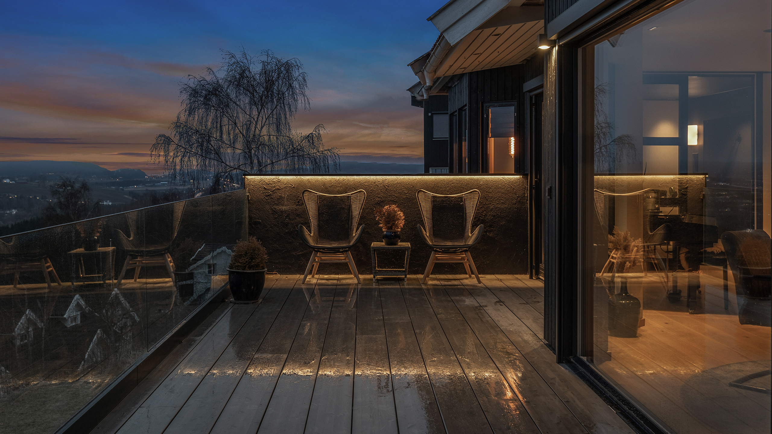 En våt terrasse på et hus med utebelysning fra Stokkan Lys.