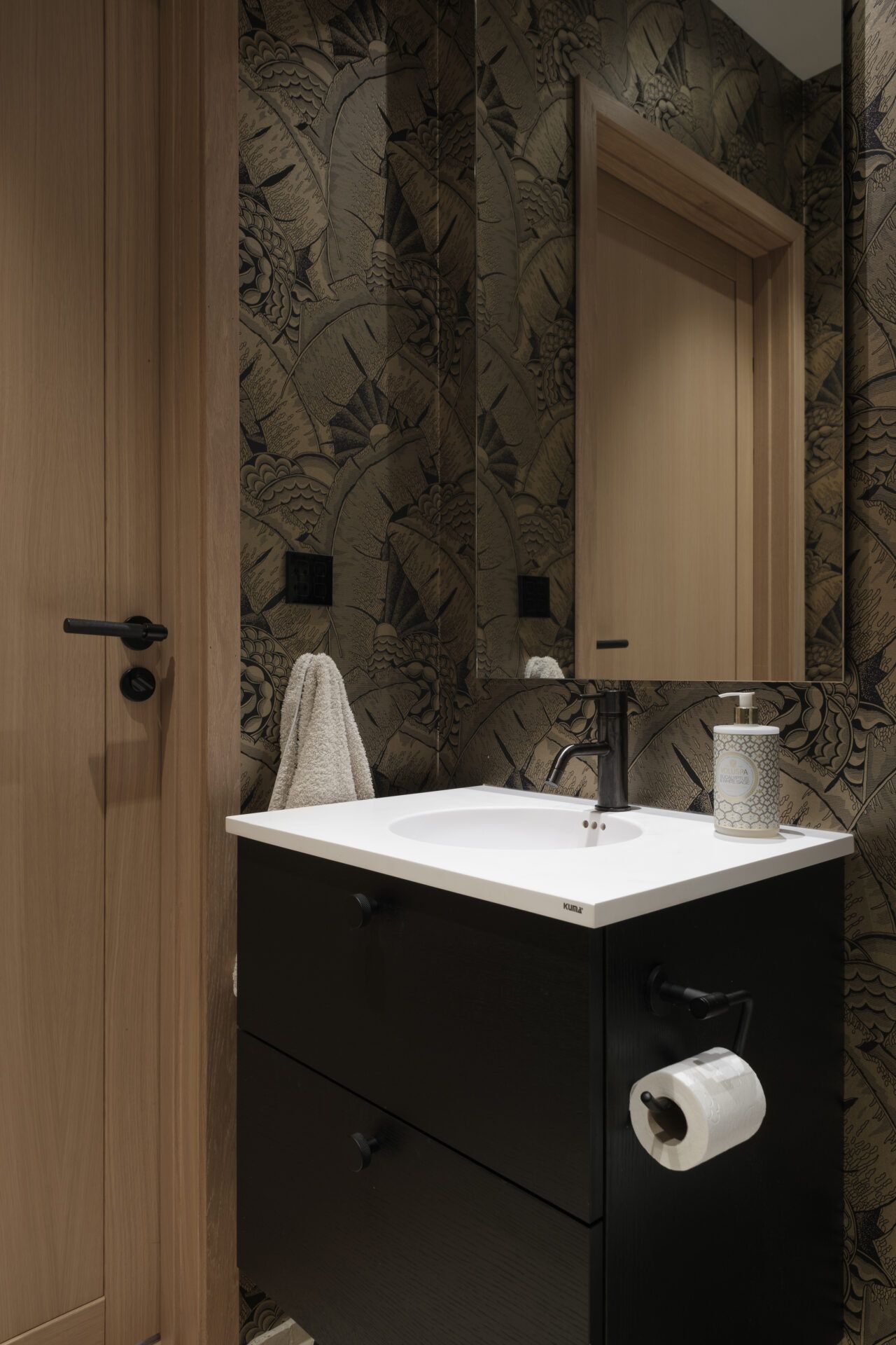 Hvit vask i et badeværelse med belysning over.