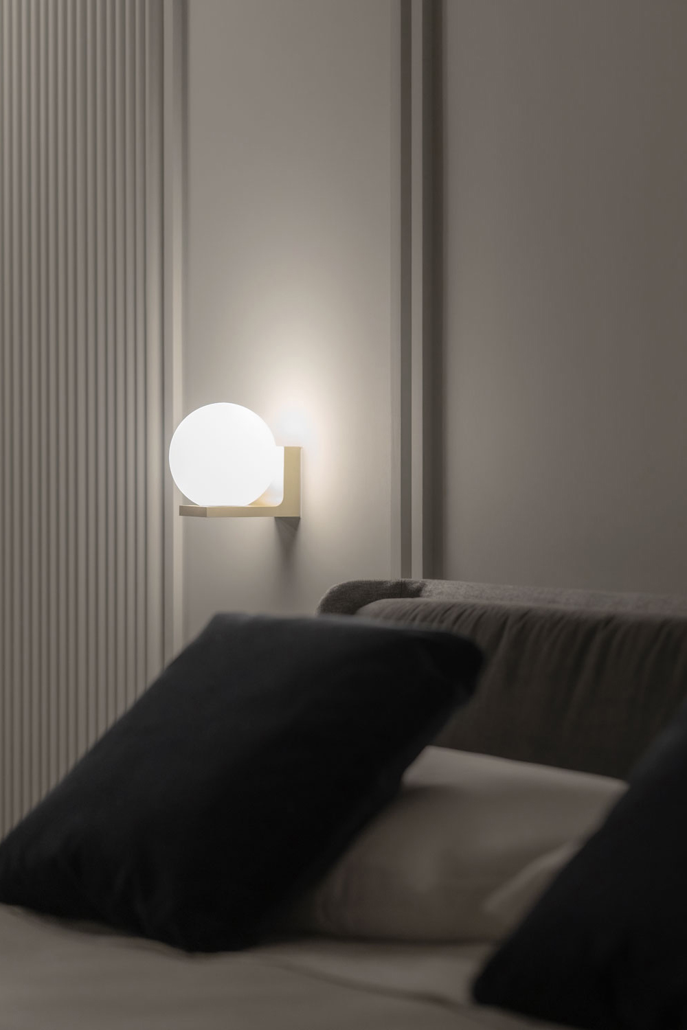Oono vegglampe over en seng.