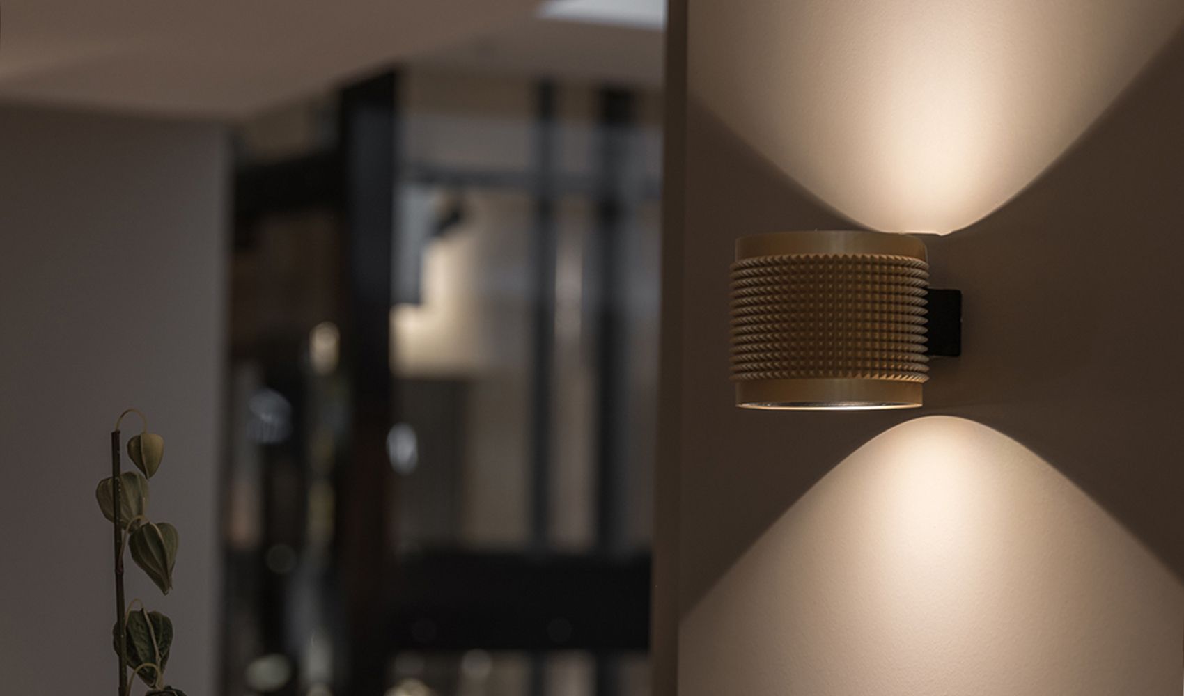 Gullfarget Punk vegglampe fra Deltalight på en vegg.