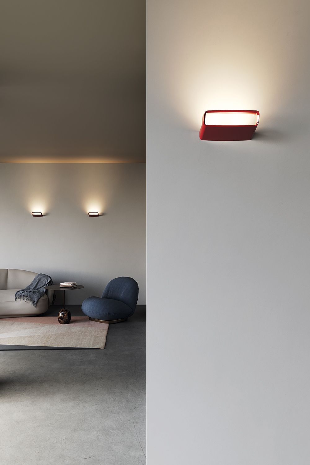 Rød Aile vegglampe på en hvit vegg.