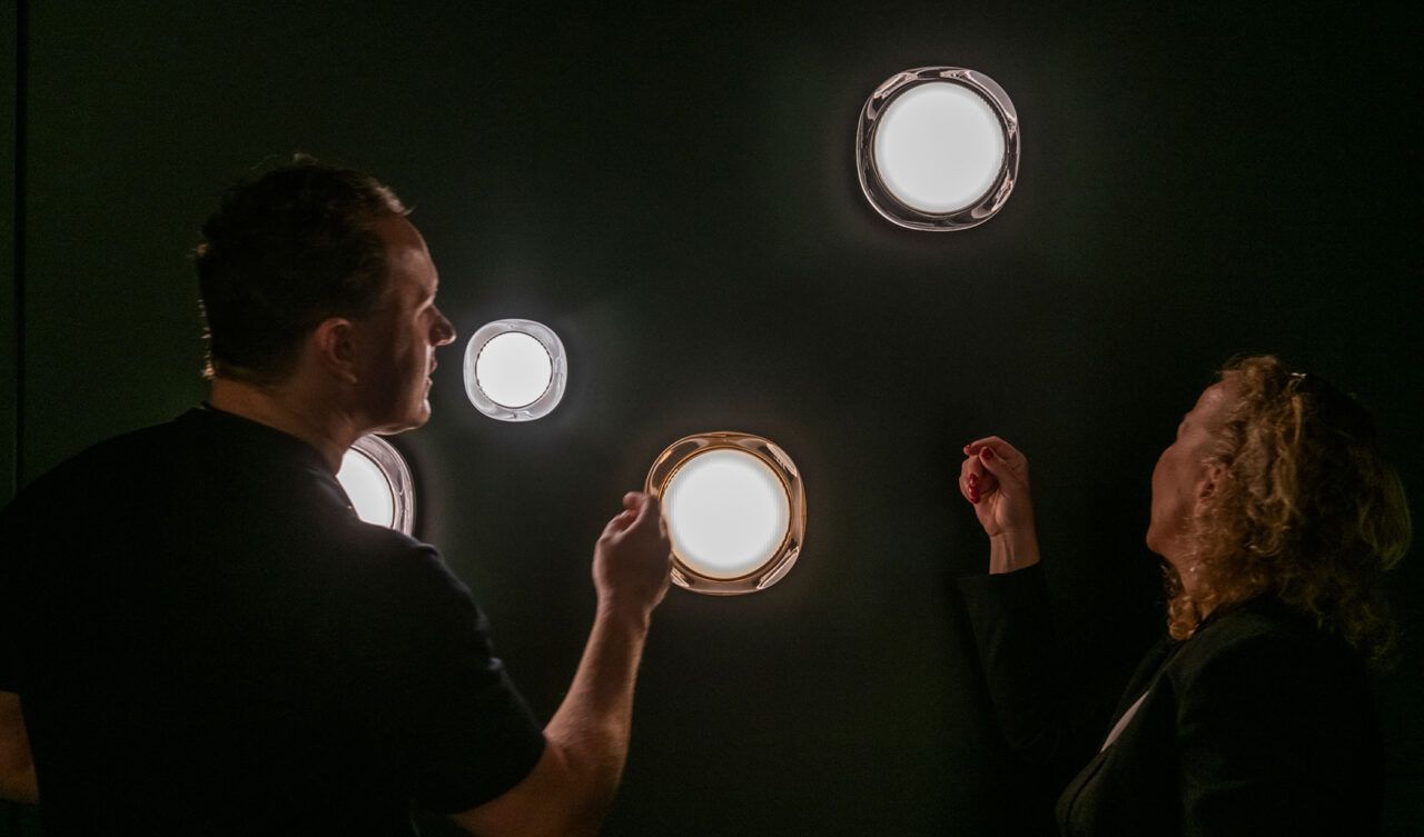 Nebbia armaturer på en mørke grønn vegg med to mennesker foran.