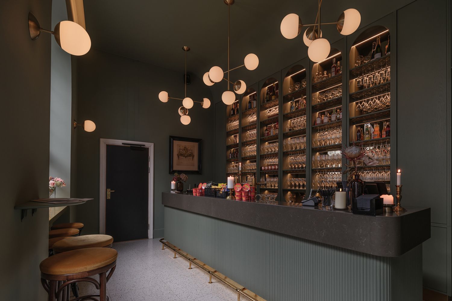 Lang serveringsdisk med pendler som henger ned fra taket over disken.