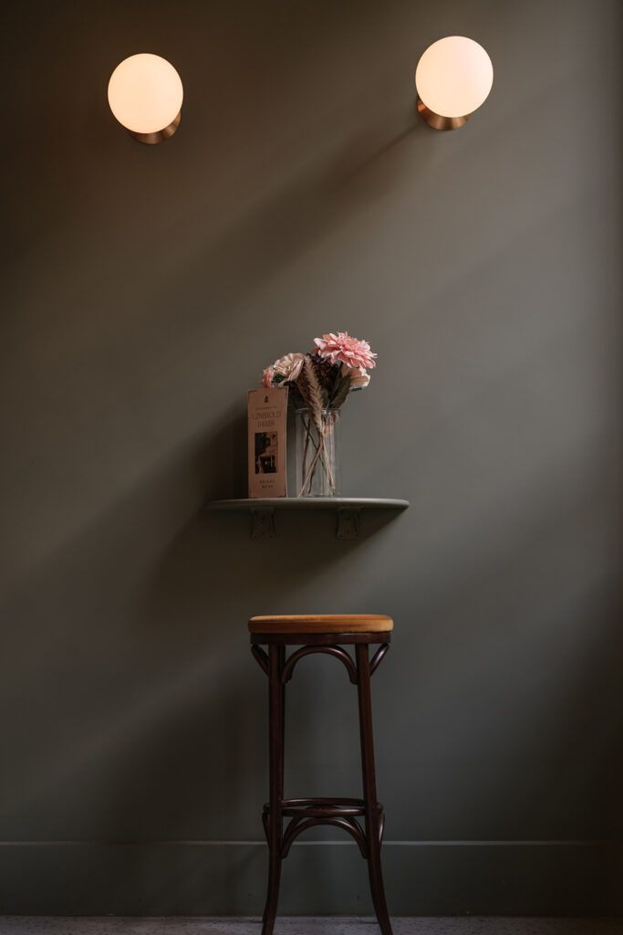 To rund vegglamper med hvit kuppler på en grønn vegg.