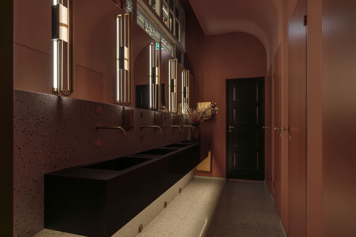 Belysning ved siden av speil over vasker inne på et toalett.