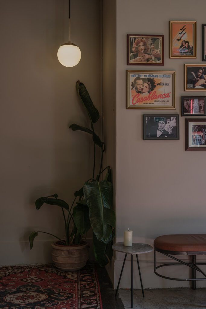 Hjlerne med plane, bilder på vegg og rundt hvit lampe som henger i taket.