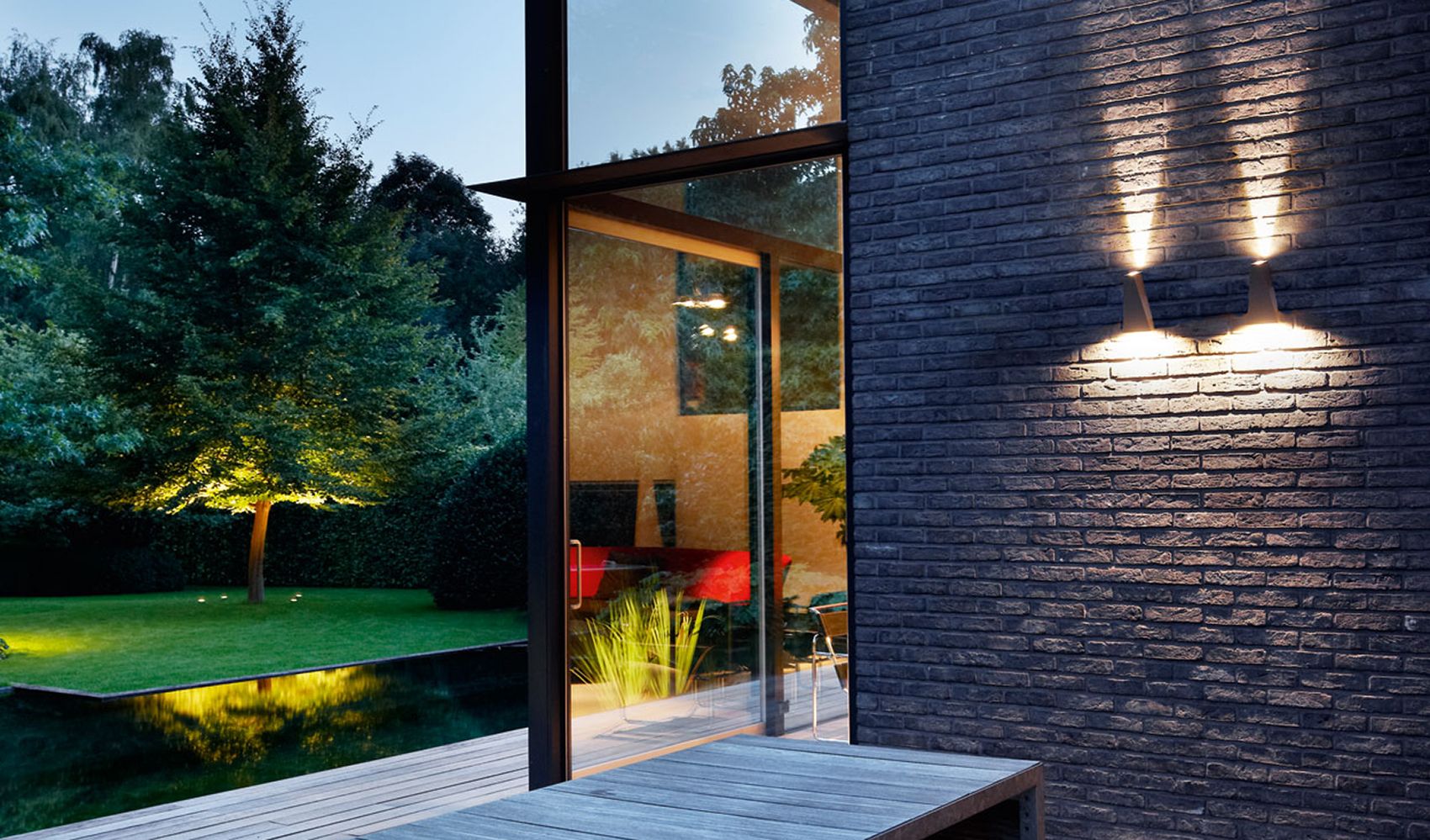 To Topix vegglamper fra Deltalight på en murvegg.