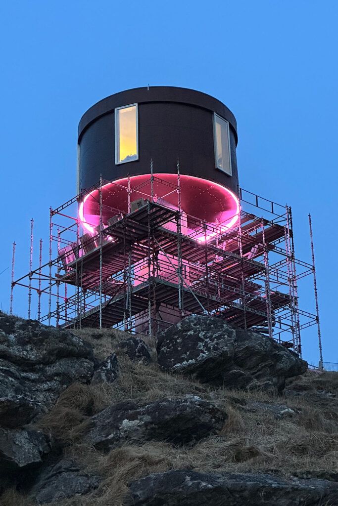 Stillase uten på Ettertanken med rosa lys under bygget.