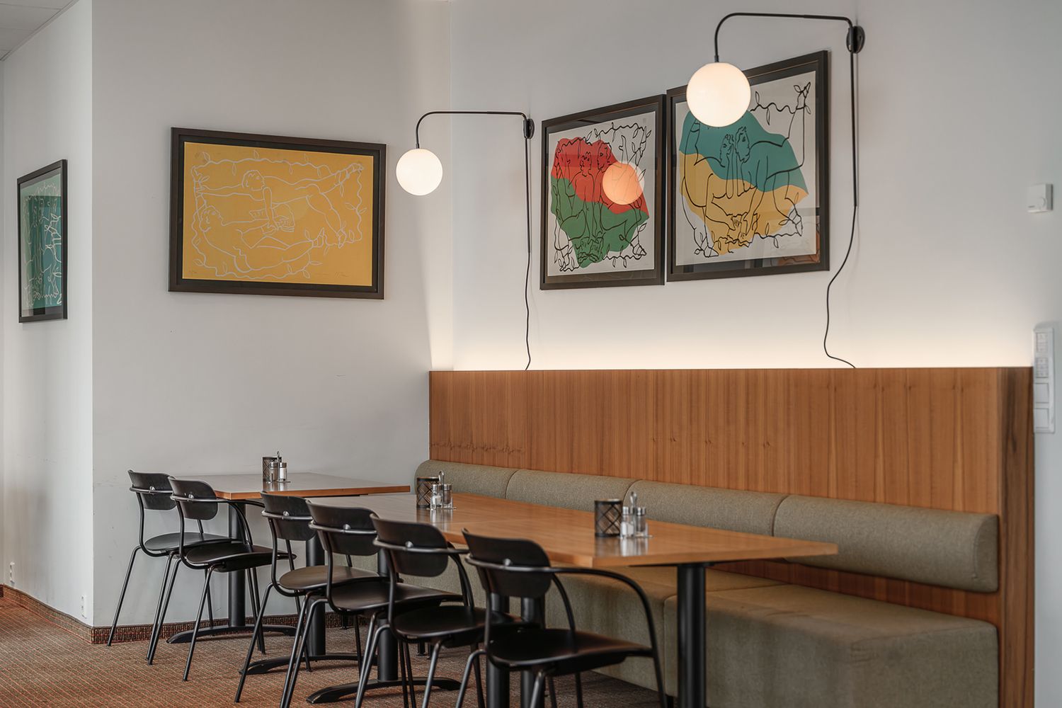 Slepelys bak en sofa og to vegglamper på veggen.