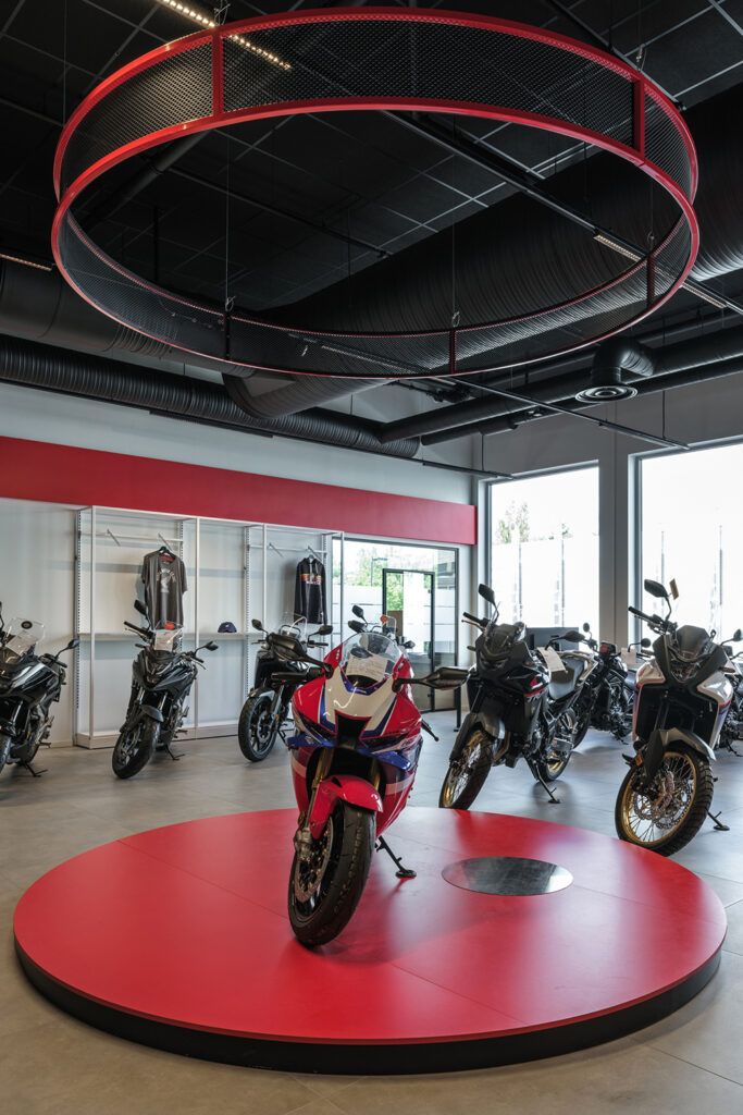 Utstilt motorsykkel på et rødt platå med belysning over.