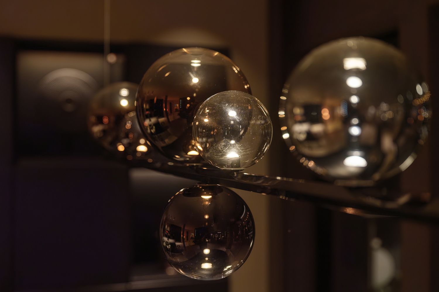 Nærbilde av glasspendel med amberfargede glass.