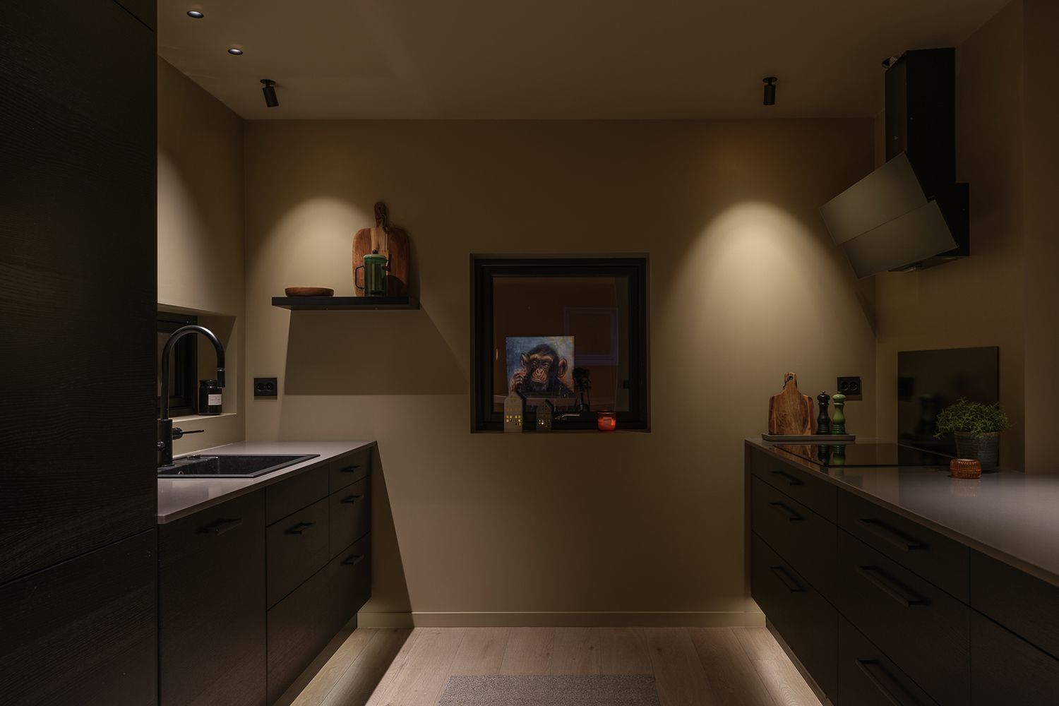 Et kjøkken med utenpåliggende downlights i taket som lyser ned på kjøkkenet.