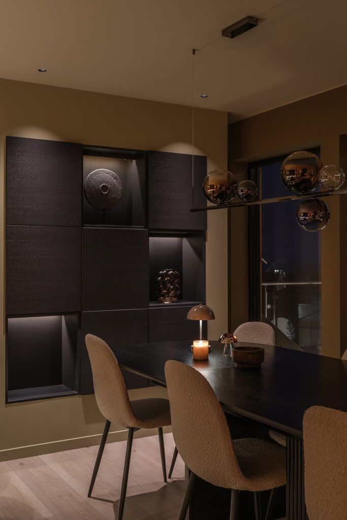 Downlights i taket som belyser en sort reol.