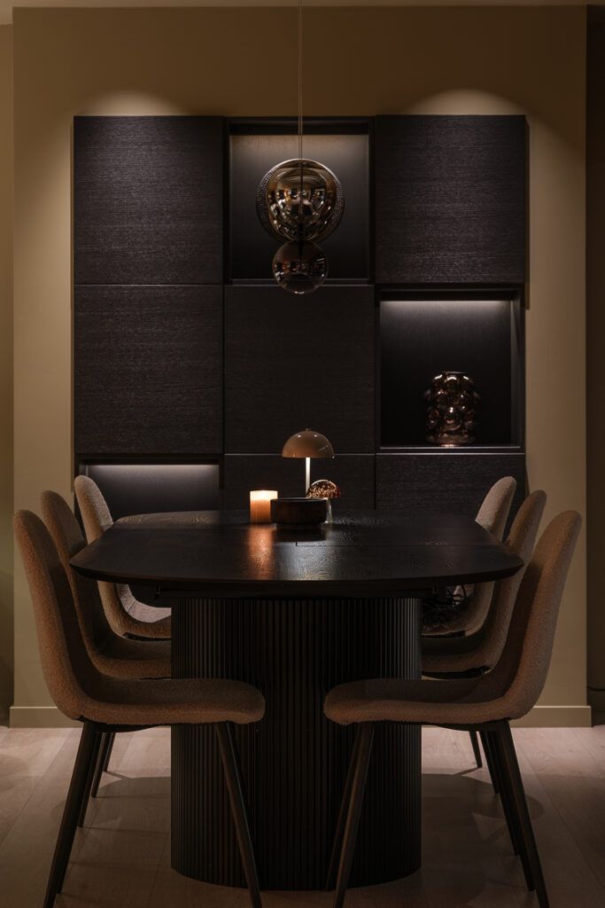 Downlight i taket som belyser en veggreol ved en spisestue.