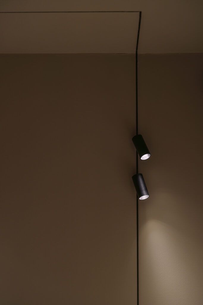 To sorte spotter på veggen.