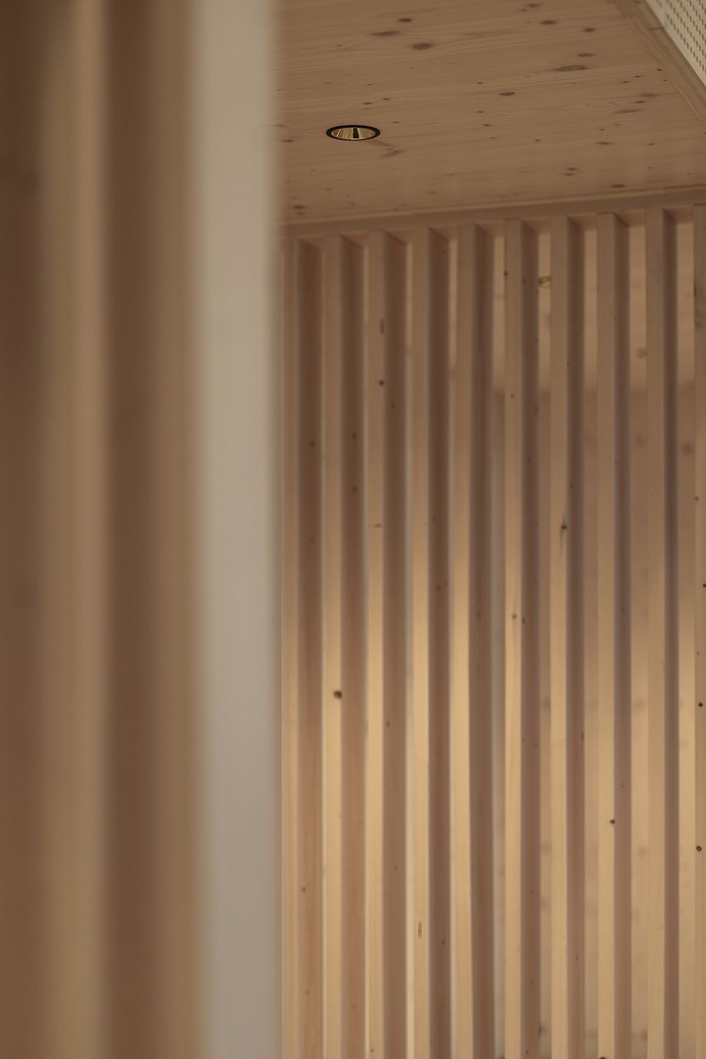 Downlight som belyser spiler i treverk.