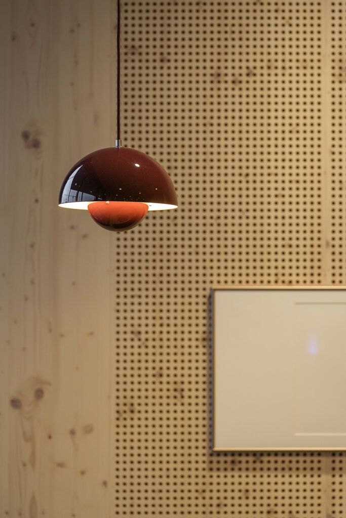 En rød pendellampe som henger ned fra et tak i Cissy Klein VGS i Trondheim.