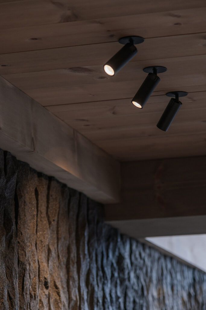 Tre sorte spotter som belyser en vegg.