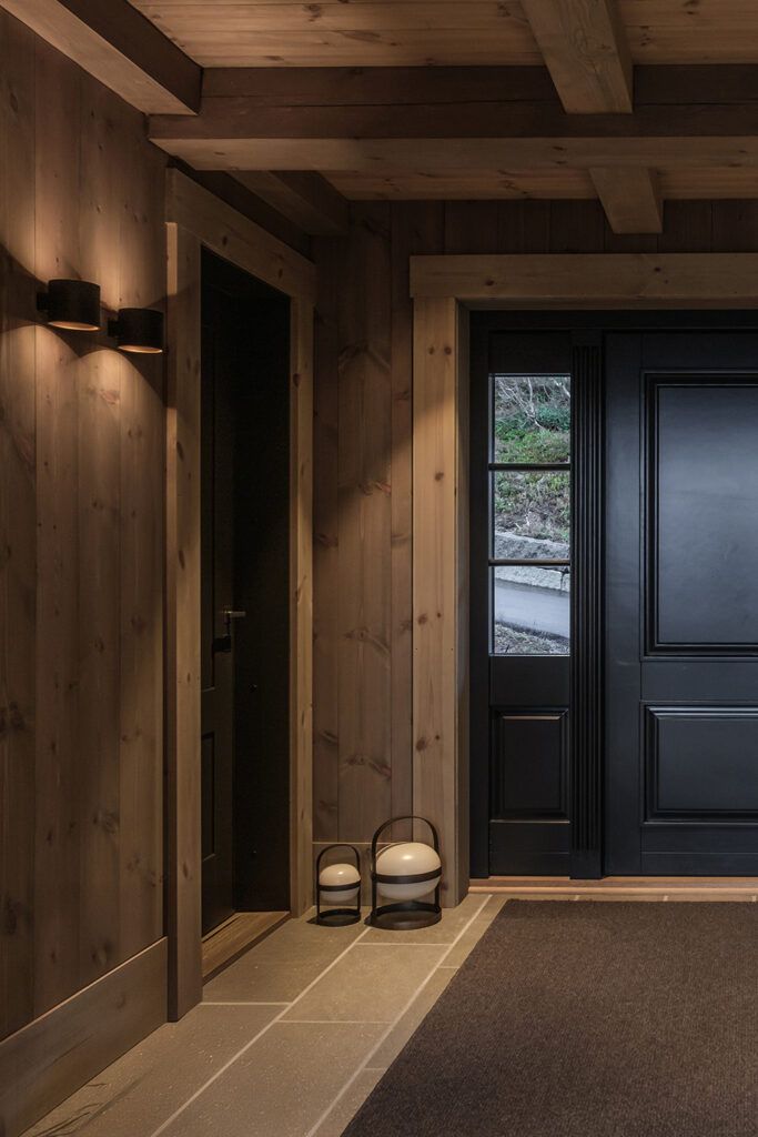 To vegglamper som lyser opp og ned i gangen på Orretunet hytte på Strandafjellet.