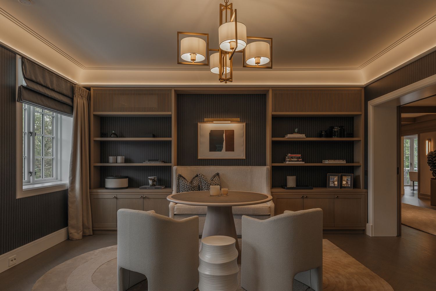 Slepelys mot tak og en lysekrone midt i rommet av en stue.