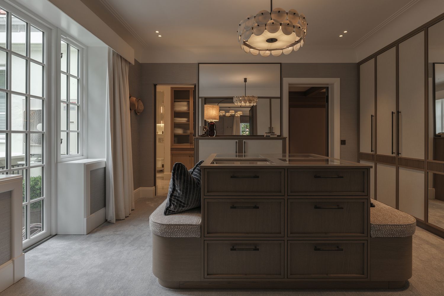 Walk-in-closet med pendel og downlights i taket.