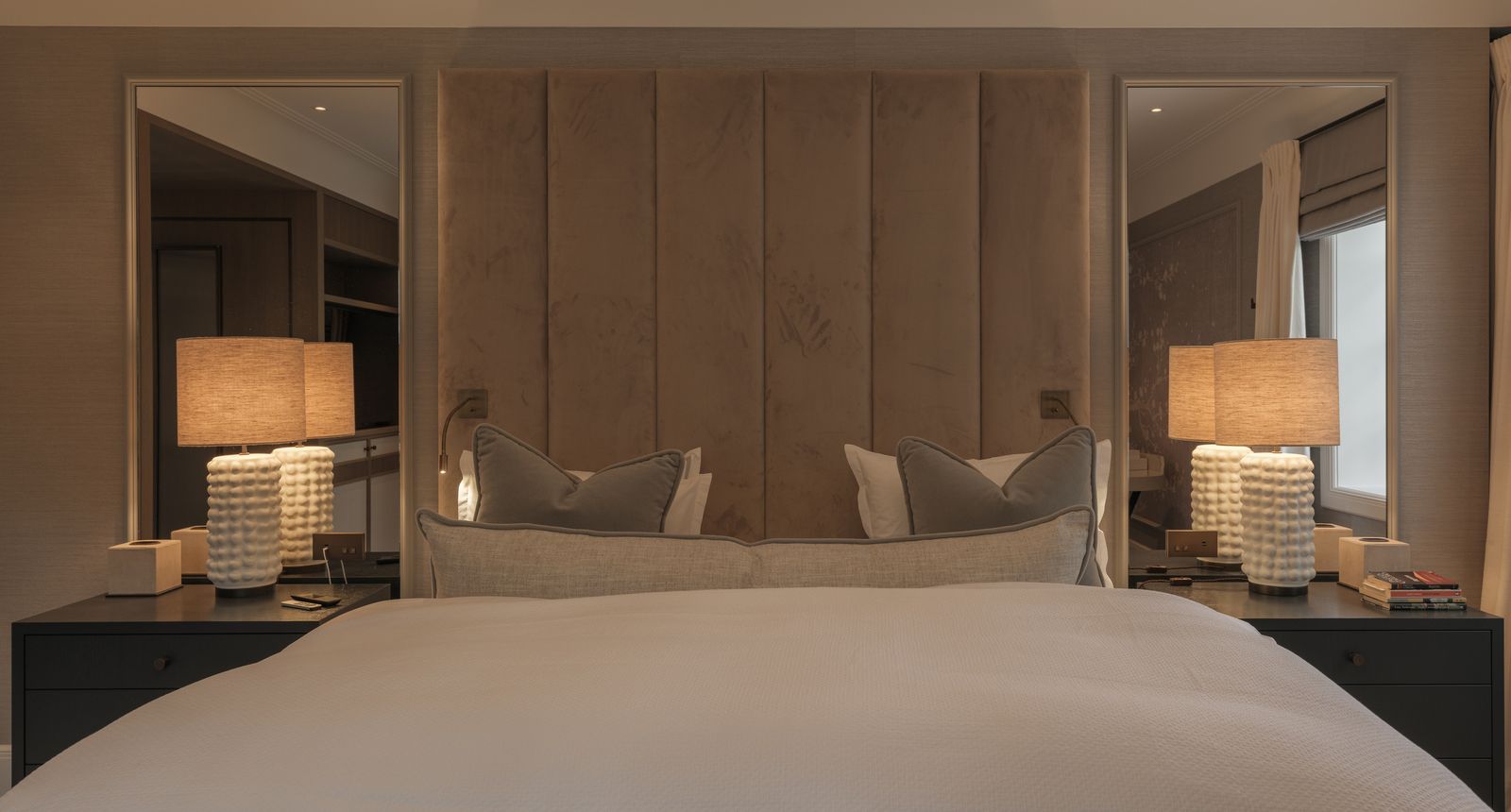 Dobbeltseng med store nattbordslamper på hver side av sengen.