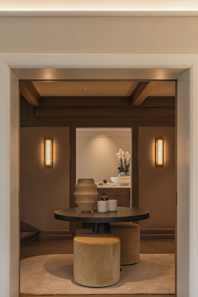 Vegglamper på hver sin side av et speil i en gang.