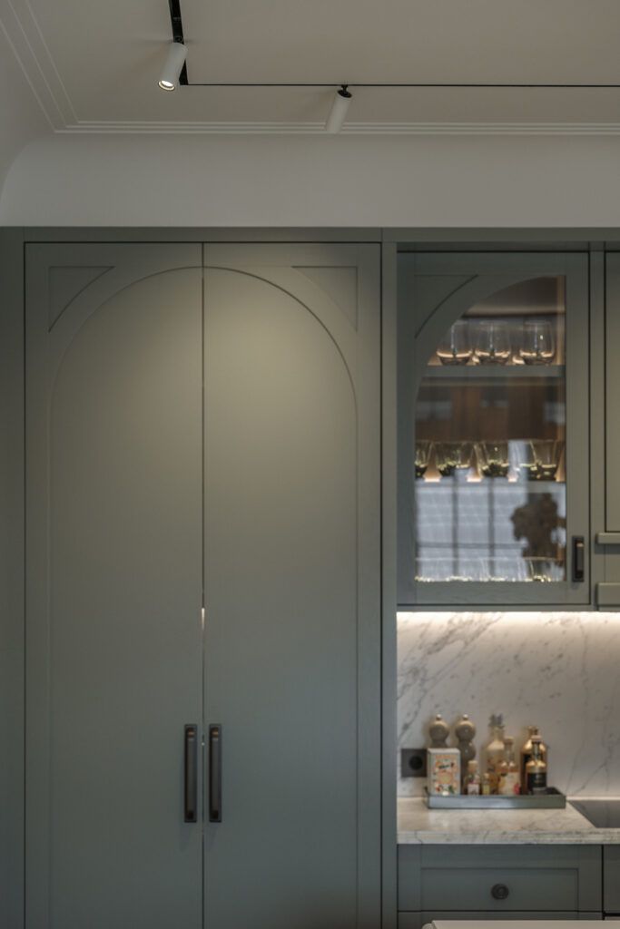 Hvite spotter i tak belyser grønne kjøkkenskap i leilighet i Drammensveien.