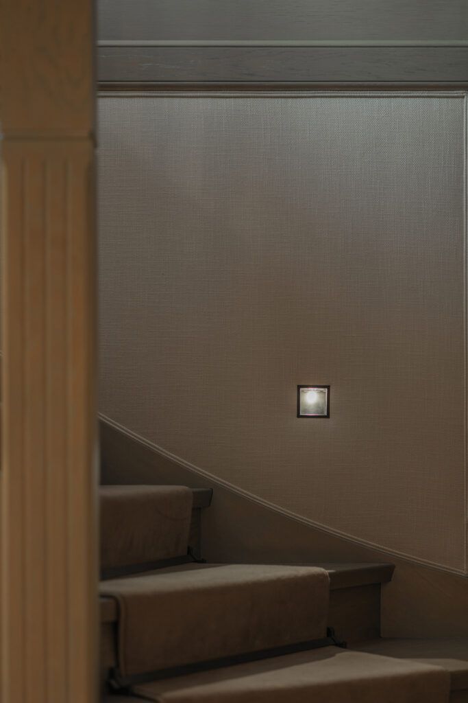 Innfelt belysning i vegg som belyser trappetrinn.