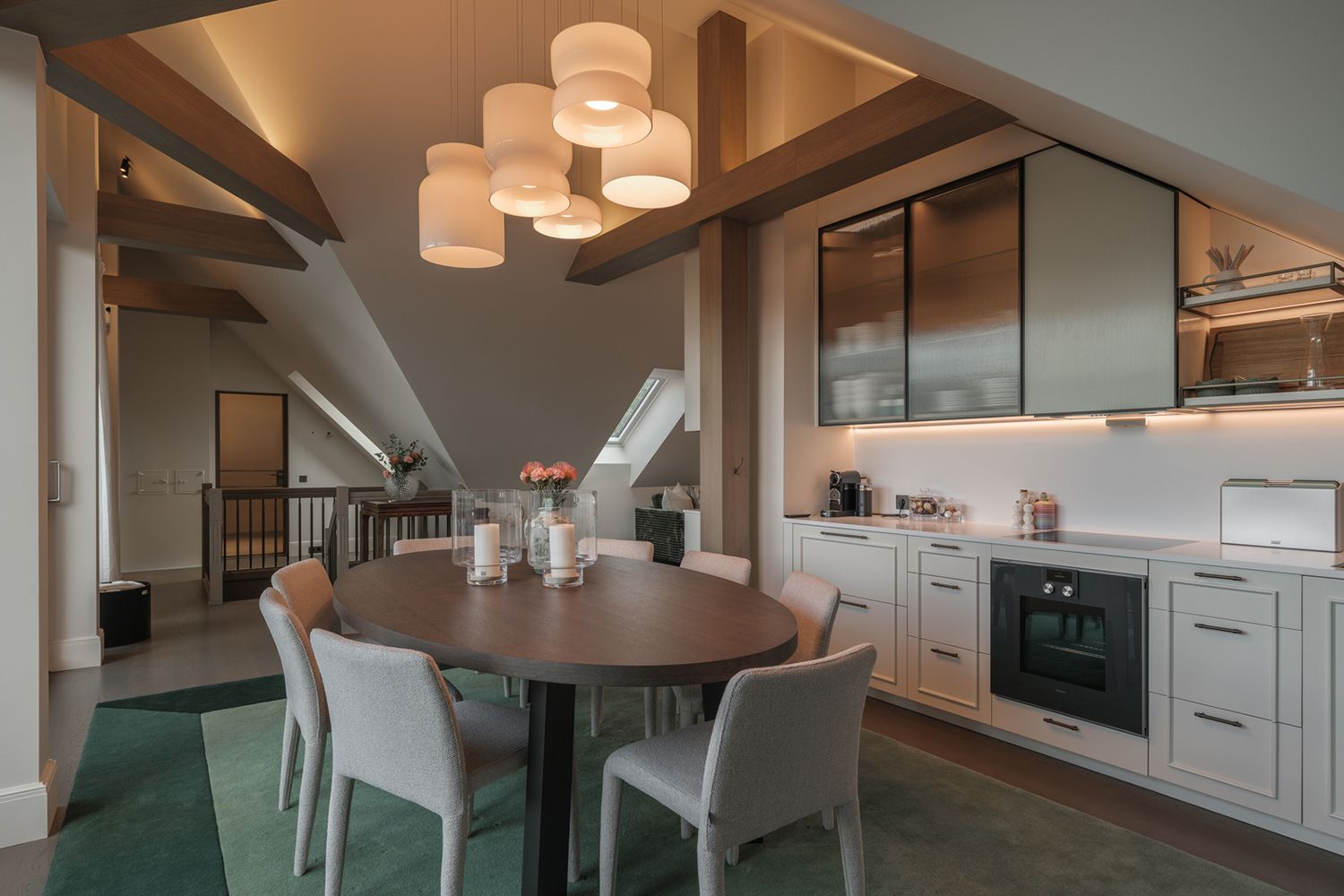 Belyst kjøkken med bjelker i taket.