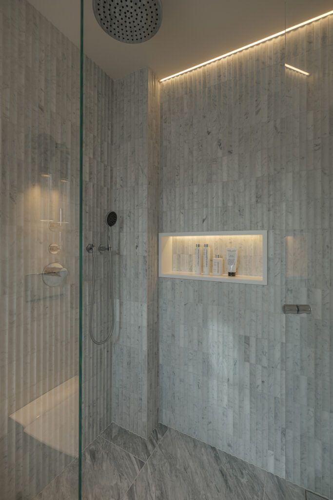 Slepelys nedover en flislagt vegg i et dusjhjørne