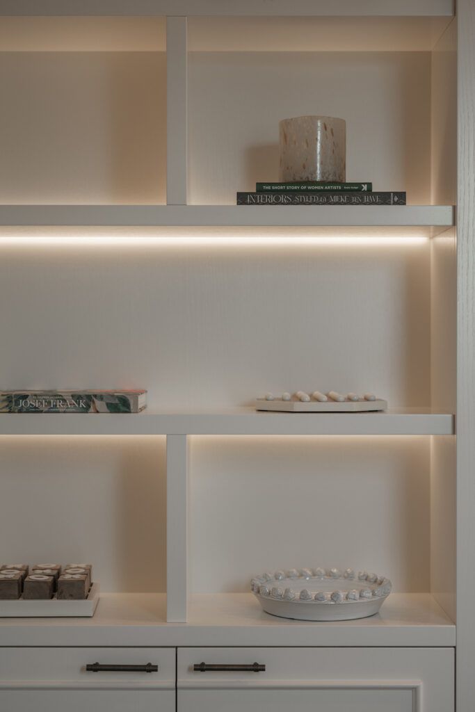 Hvit reol med belysning under hyllene.