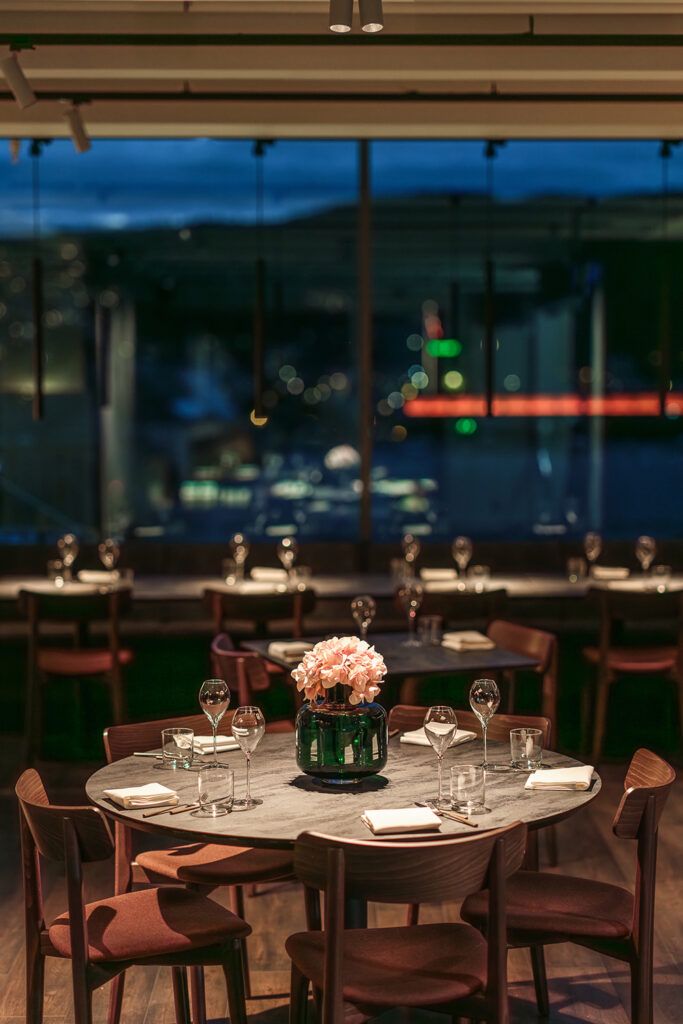 Rundt spisebord belyst av to spotter i taket.