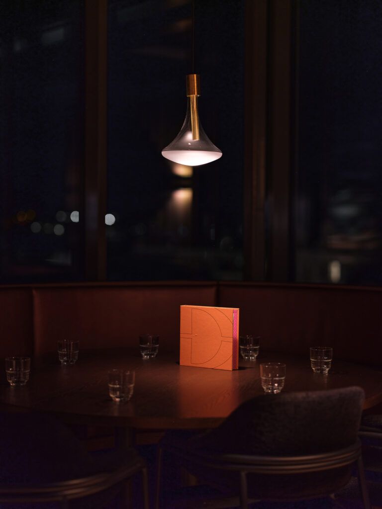 Cathode pendel fra Davide Groppi over et bord.