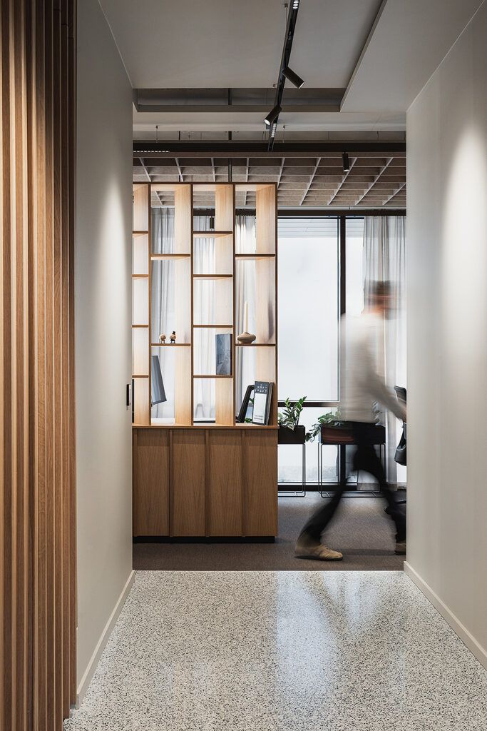 Sort skinne med spotter i et tak som belyser vegger inne hos Bjerke Eiendom sine kontorer.