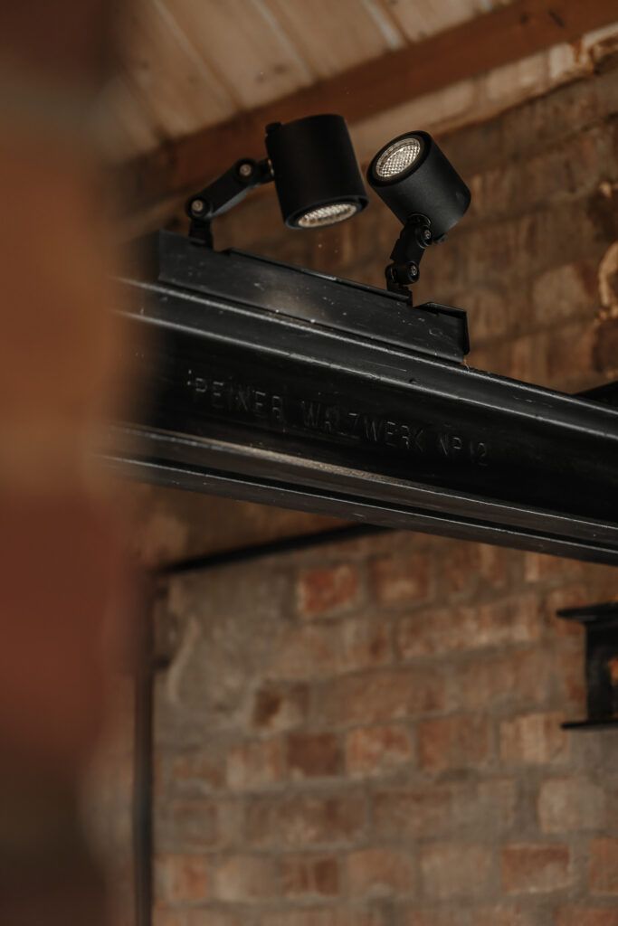 To sorte spotter på en bjelke i et tak.