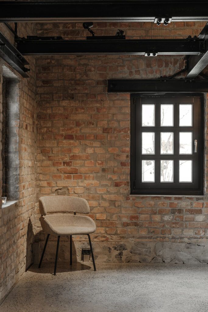 En belyst stol i et hjørne med murvegger av teglestener.