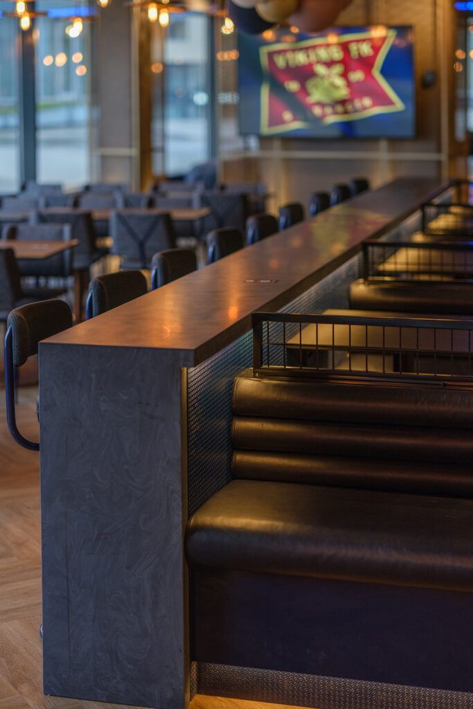 Skinnsofaer mot et barbord med slepelys.