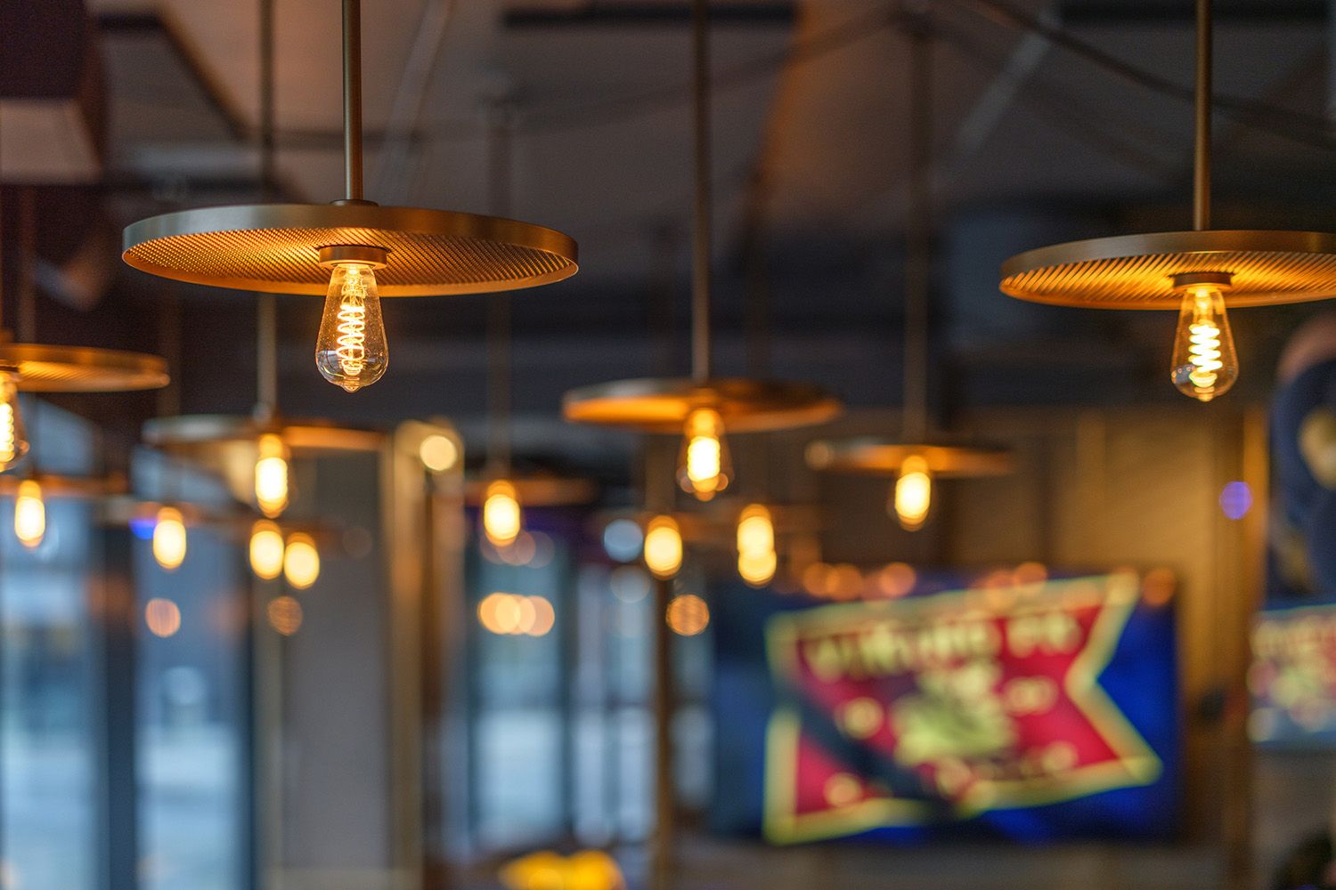 Nærbilde av kobberfargede pendler i taket.