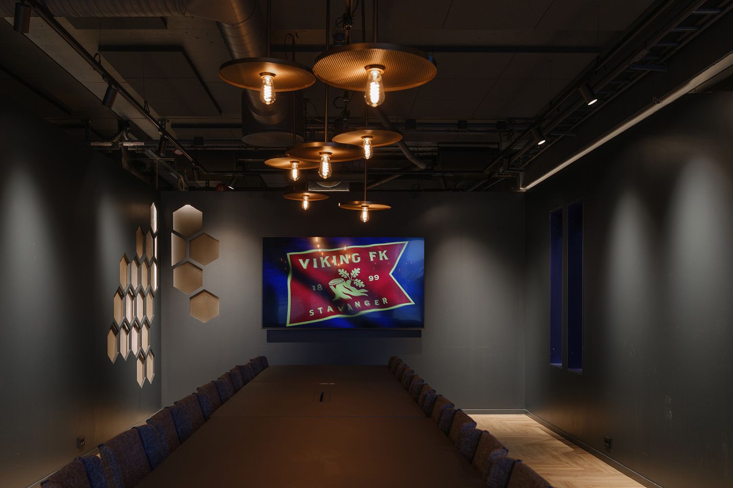 Belyst rom med et langbord i Viking Pub.