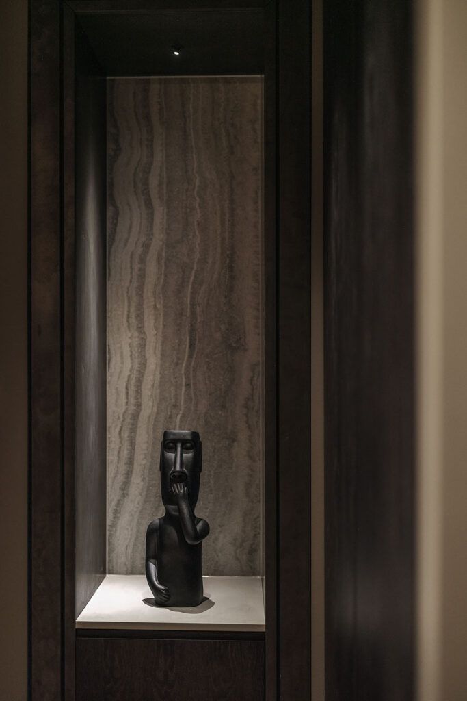 Liten downlight i en nisje som belyser en statue.