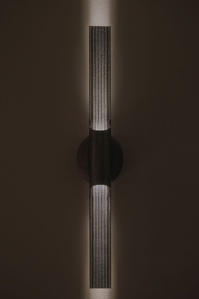 Dekorativ vegglampe på en mørk vegg i bolig i Bykronen i Stavanger.