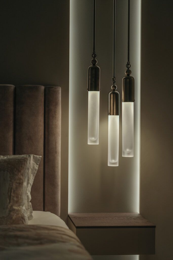 Tre dekorative pendler ved siden av en seng.