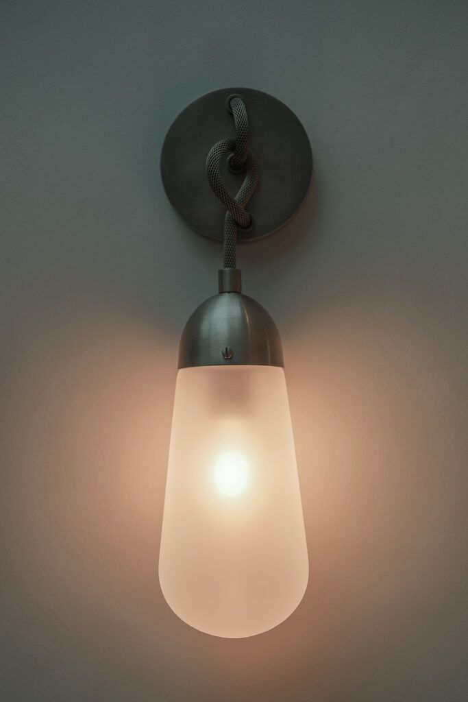 Dekorativ vegglame med lys i på en vegg.