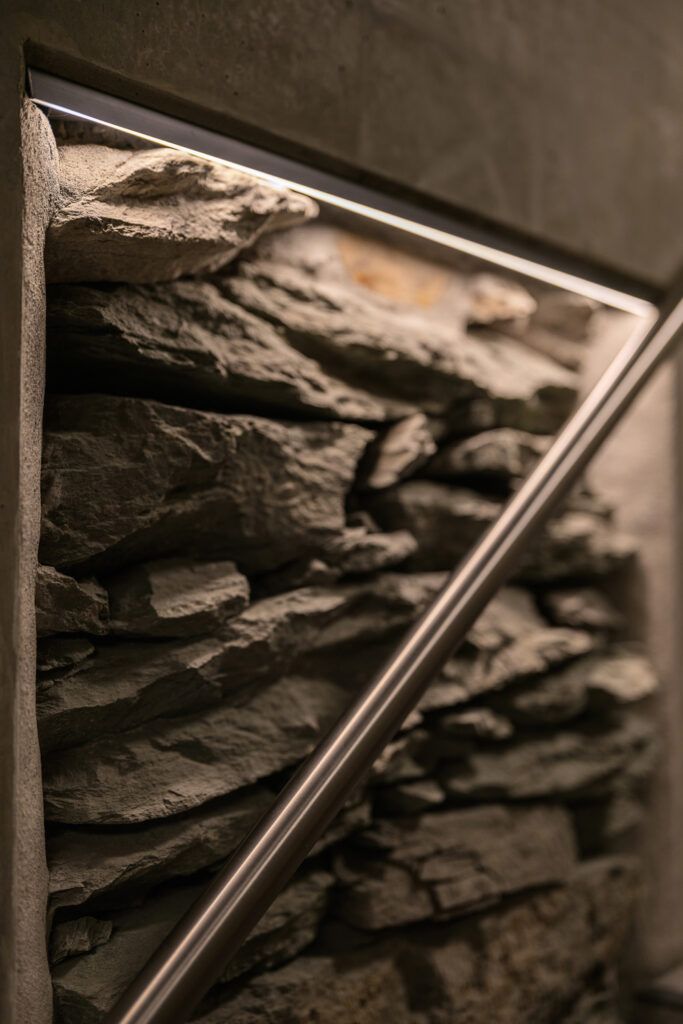 Slepelys langs en vegg med stein i Kjøpmannsgata 15 i Trondheim.