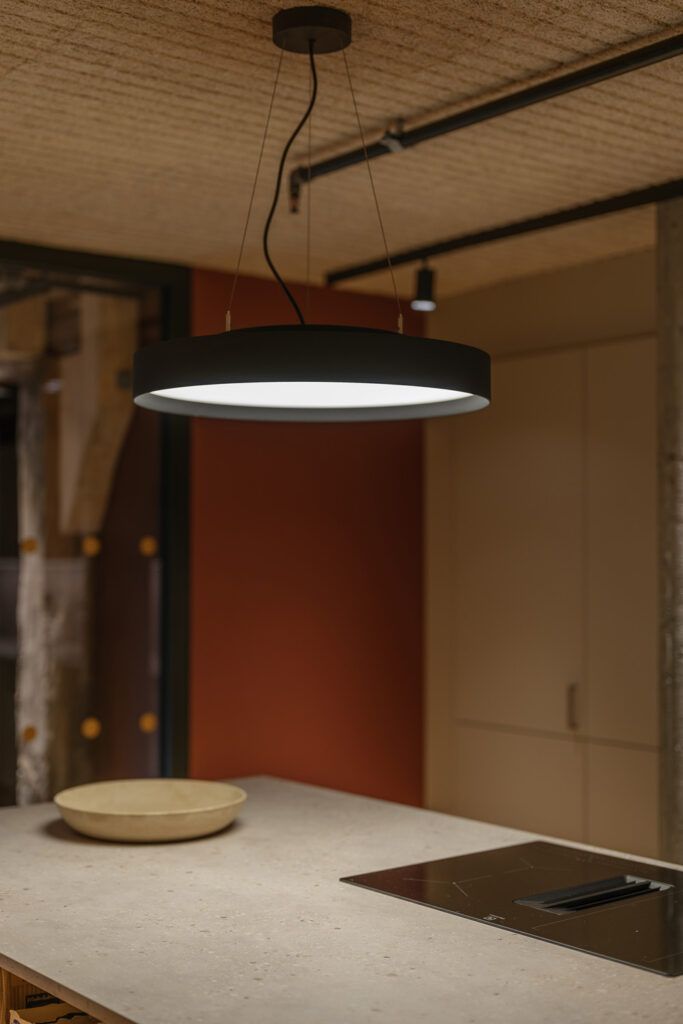 Rund flat pendel over en kjøkkenøy.