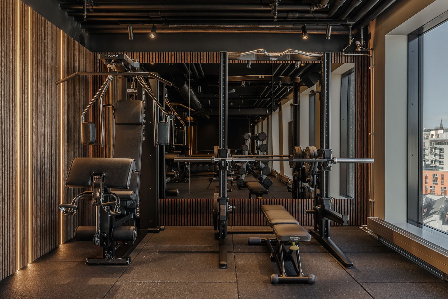 LED-lister i vegg og spotter i taket i et treningsrom.