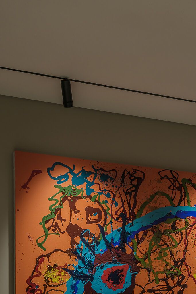 Nærbilde av sort spot i et tak som belyser et maleri