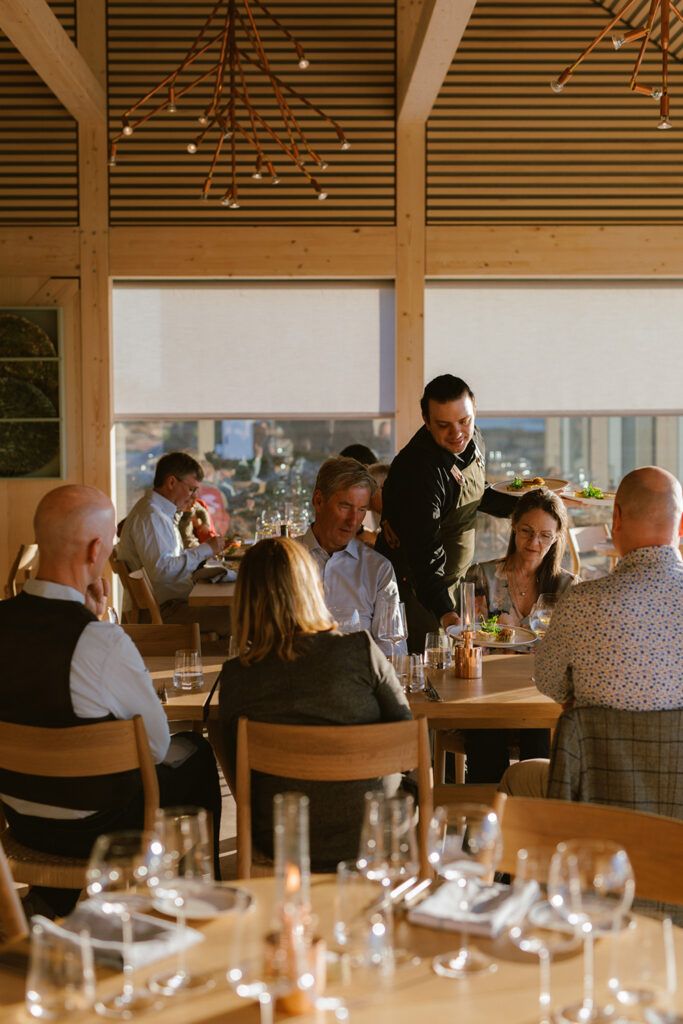 Mennesker rundt et spisebord i restauranten på Ytri Island retreat på Træna.