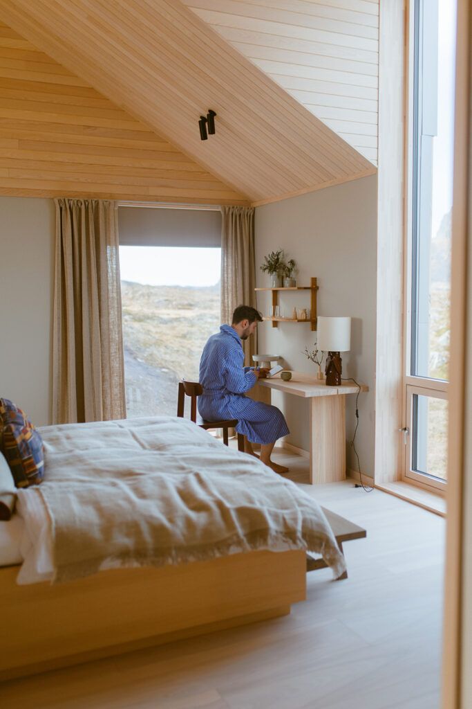 Mann sitter i ved et skrivebord inne på et værelse.